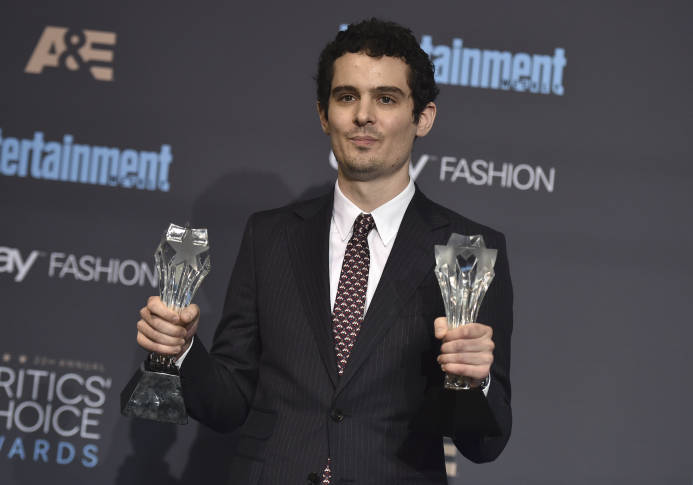 Damien Chazelle poses in the press room with the awards for best picture and best director for "La La Land" at the 22nd annual Critics' Choice Awards at the Barker Hangar on Sunday, Dec. 11, 2016, in Santa Monica, Calif. (Photo by Jordan Strauss/Invision/AP)